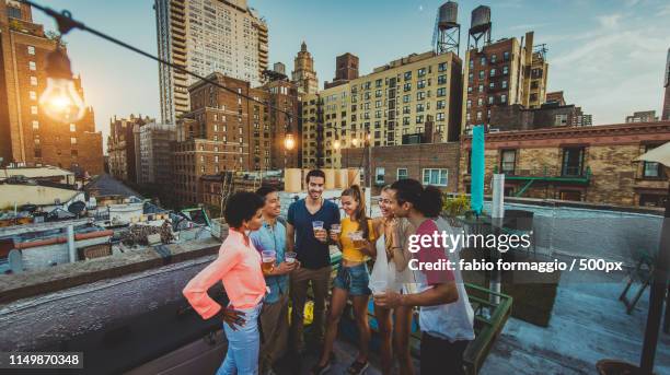 group of friends having party on a rooftop - rooftop new york photos et images de collection