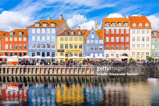 multicolored houses along the canal in nyhavn harbor, copenhagen, denmark - copenhagen stock-fotos und bilder