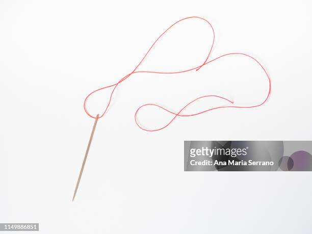 a needle with red thread - arte de la costura fotografías e imágenes de stock