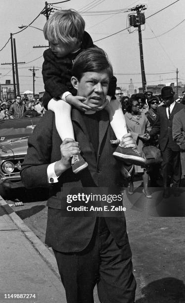 View of marchers, among them a man who carries a young child on his shoulders, during the 'Walk for Understanding' through the Central Ward...