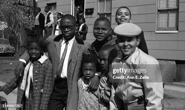 Portrait of a man, along with several children, as they pose along the route of the 'Walk for Understanding' through the Central Ward neighborhood on...