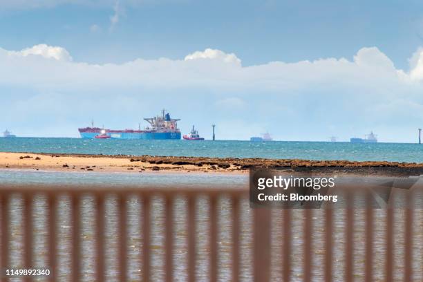 Tugs escort a bulk carrier loaded with iron ore out to sea from the port in Port Hedland, Australia, on Monday, March 18, 2019. The two parts of the...