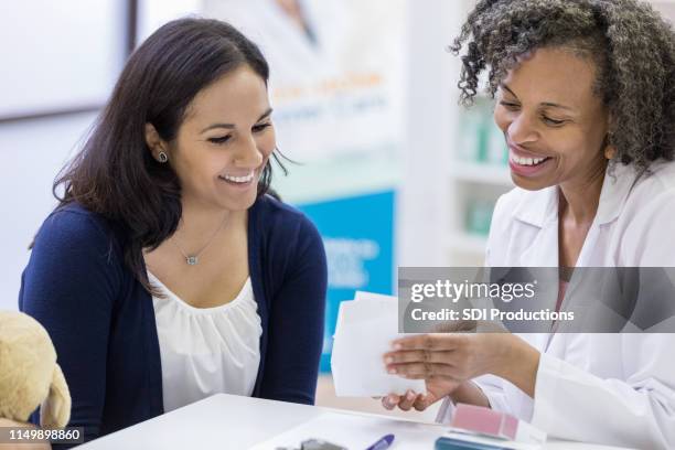 mature female pharmacist reviews patient's medication - pharmacist and patient stock pictures, royalty-free photos & images