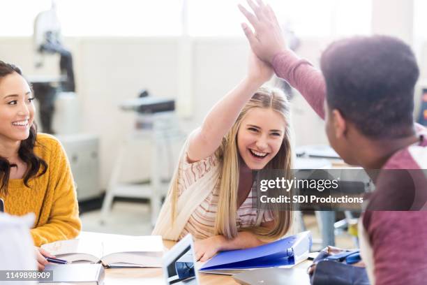 high school classmates high five each other - high five stock pictures, royalty-free photos & images