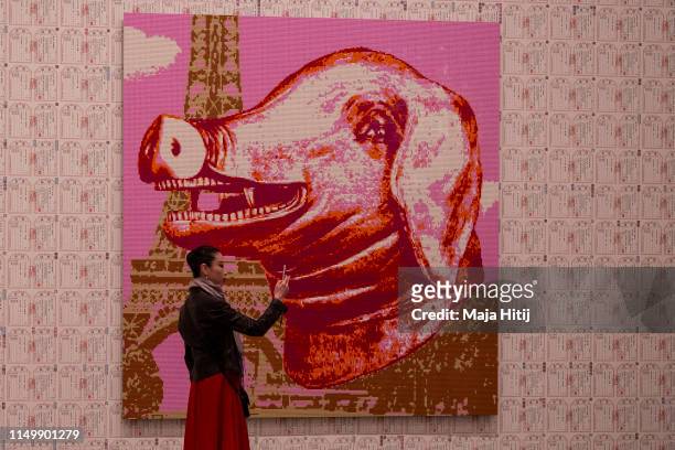 Visitor takes a selfie next to the "Zodiac" series LEGO portrait series made by Chinese artist and political activist Ai Weiwei during opening of...