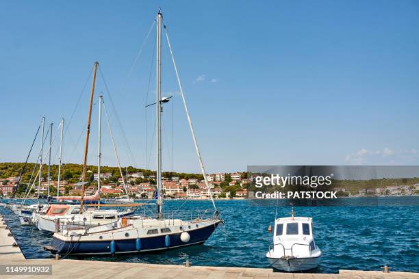 yachts moored by the strait dividing mainland and murter island, tisno, croatia - marina stock pictures, royalty-free photos & images