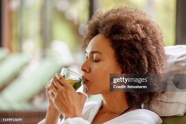 drinking herbal tea at the wellness resort - woman drinking tea stock pictures, royalty-free photos & images