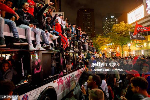 Toronto Raptors fans celebrate atop and inside a bus on Yonge St. After the team beat the Golden State Warriors in Game Six of the NBA Finals, on...