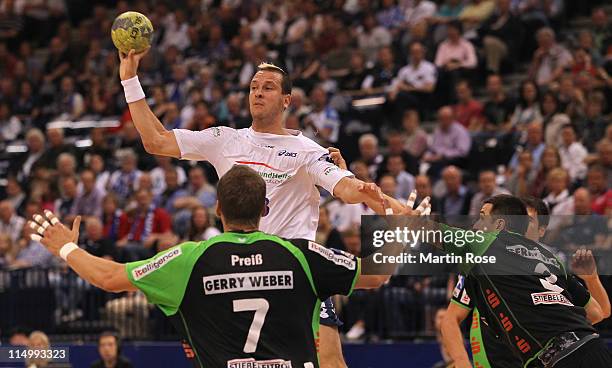 Pascal Hens of Hamburg is challenged by Sebastian Preiss and Ferenc Ilyes of Lemogo during the Toyota Handball Bundesliga match between HSV Hamburg...