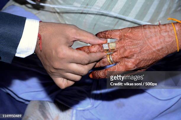 man touching rings on finger of tribal person with tattoos - tribal tattoo stock pictures, royalty-free photos & images