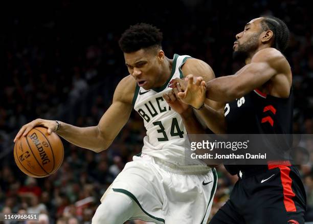 Giannis Antetokounmpo of the Milwaukee Bucks dribbles the ball while being guarded by Kawhi Leonard of the Toronto Raptors in the fourth quarter...