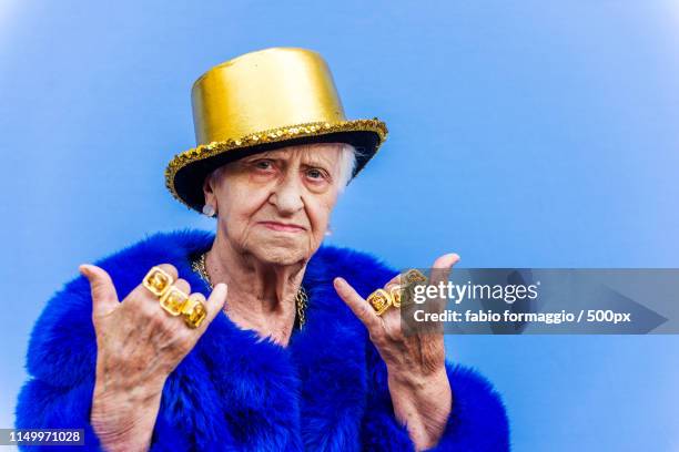 eccentric senior woman portrait - celebrities in fur stockfoto's en -beelden