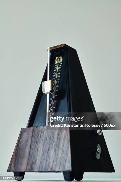 vintage metronome, on a black background - metronomo foto e immagini stock