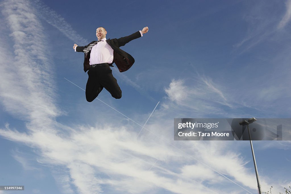 Happy business man jumping in air