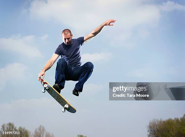 man on skateboard in mid air - monopatín artículos deportivos fotografías e imágenes de stock