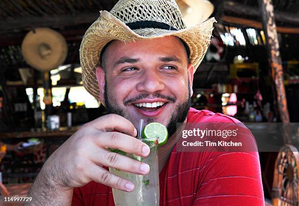 man on vacation, in beach bar with mojito, smiling - mojito photos et images de collection