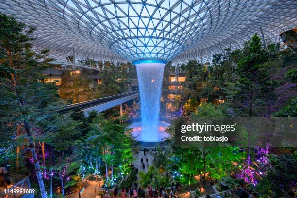 the rain vortex waterfall located inside the jewel changi airport in singapore - singapore airport stock pictures, royalty-free photos & images