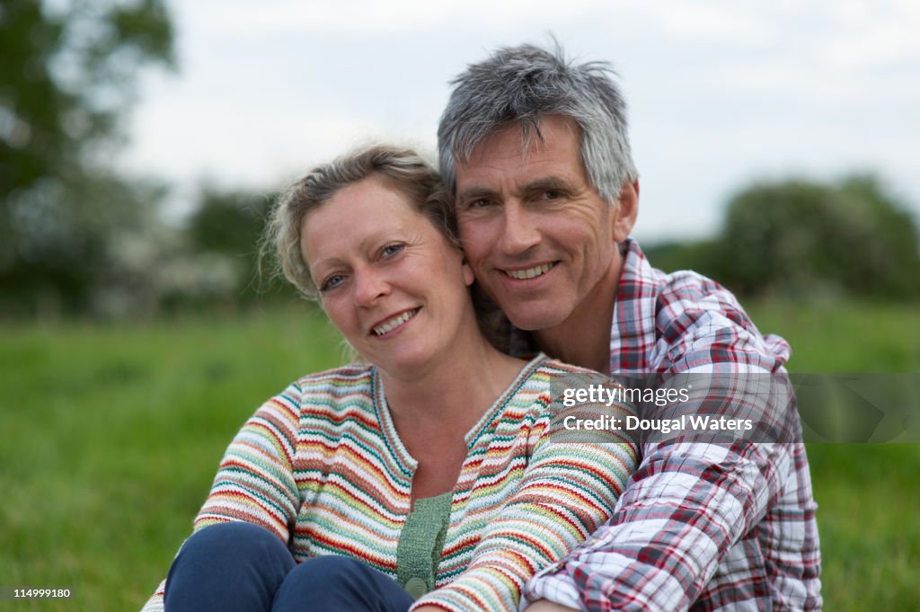 Couple embracing in countryside.