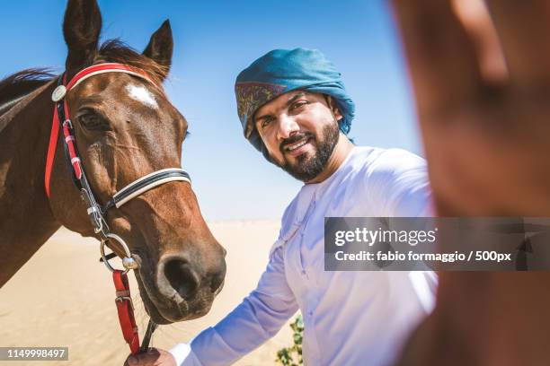 arabian man with horse in the desert - people from oman stockfoto's en -beelden