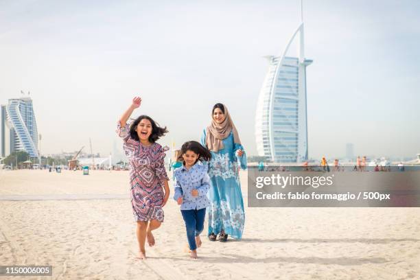 happy family in dubai - muslim woman beach stock pictures, royalty-free photos & images