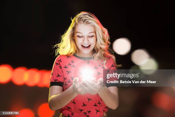 woman looking at starlight between hands. - glowing woman stock pictures, royalty-free photos & images