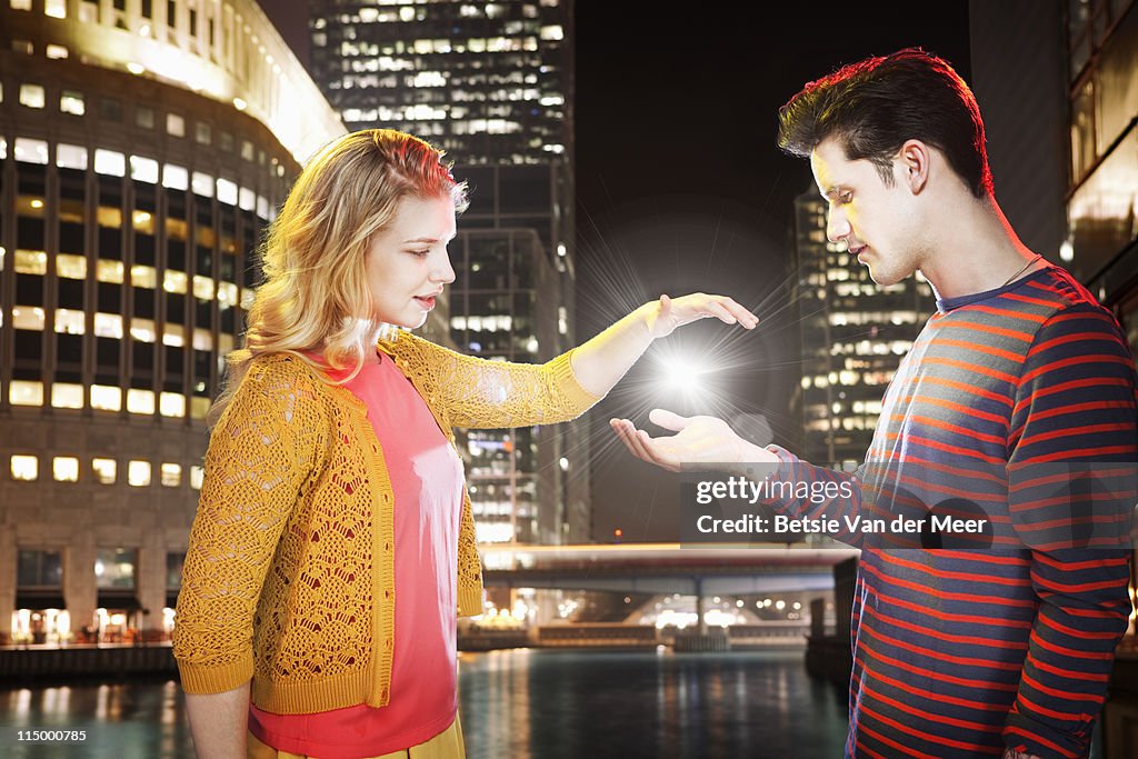 Couple capturing light between their hands.