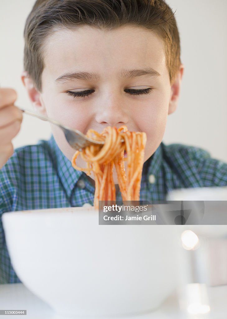 Young boy eating spaghetti