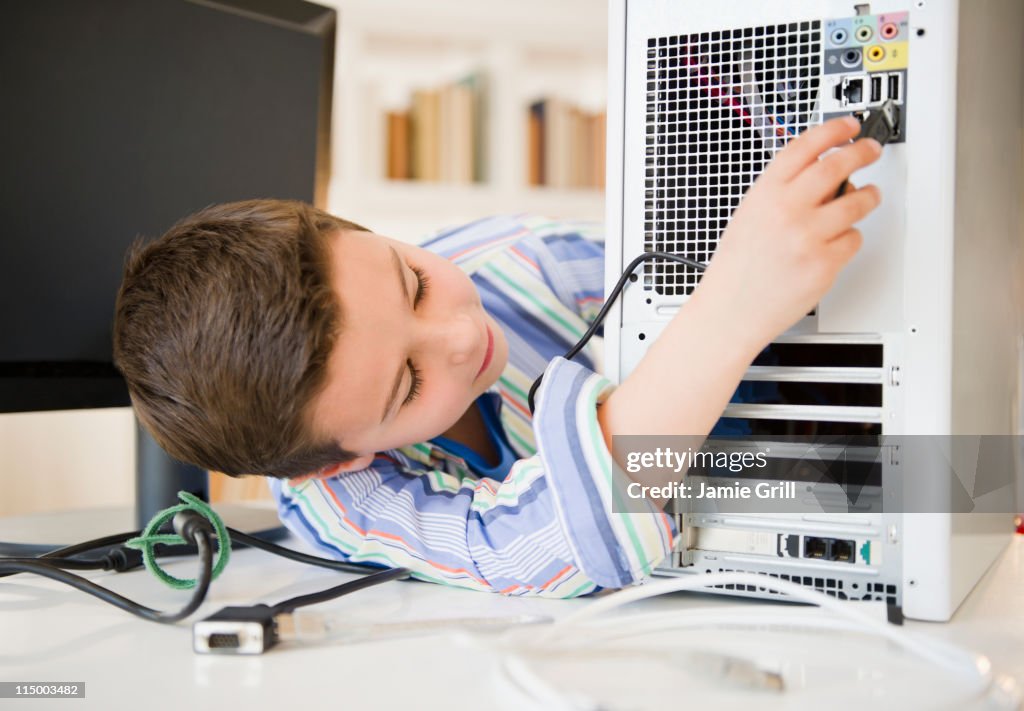 Pluggin A Computer Young Boy Plugging Wires Into Computer High-Res Stock Photo - Getty Images