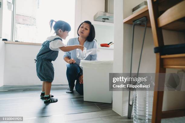 Mamma lär sin dotter hur man återvinner avfall