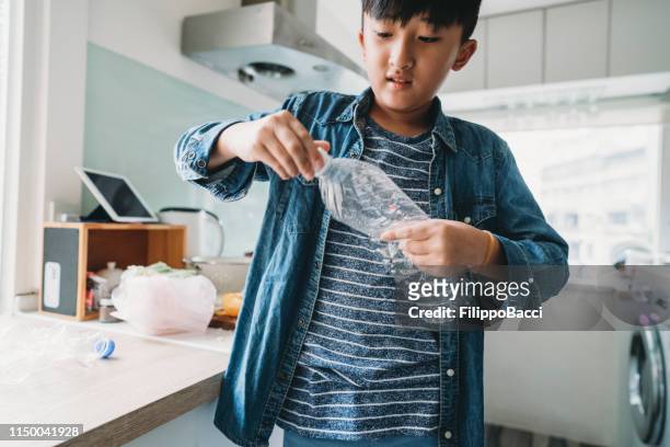 pre-adolescent child throwing away a plastic bottle - plastic bottle stock pictures, royalty-free photos & images