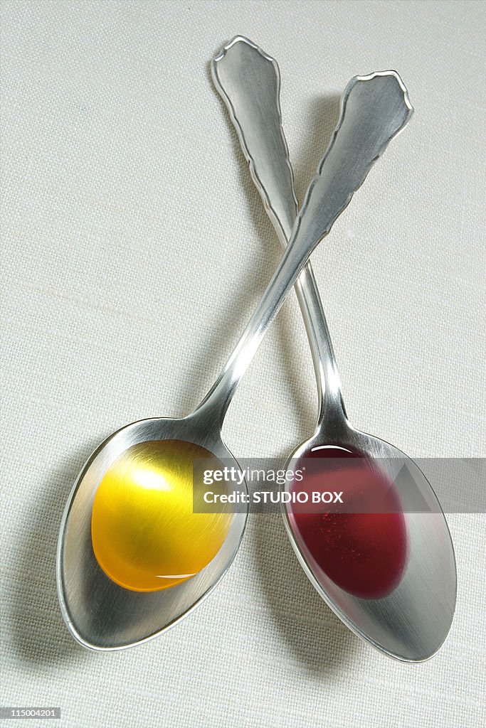 Two spoons with olive-oil and vinegar (overhead vi