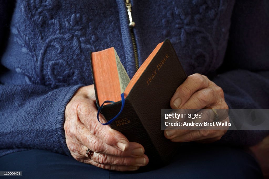 Senior woman's hands holding open the Holy Bible