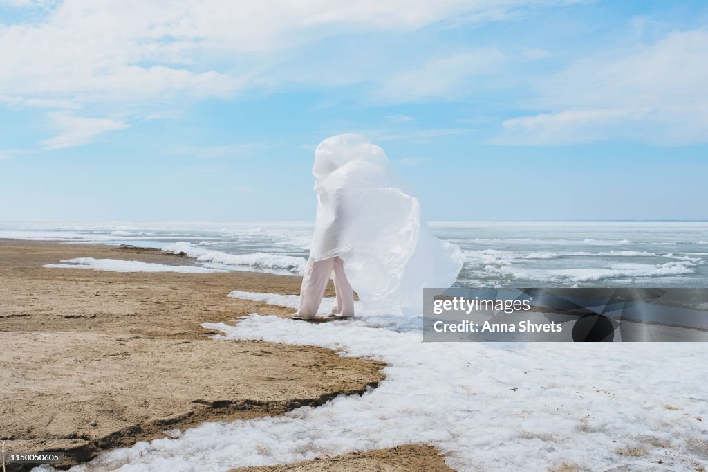 Man Wearing Plastic Against Sky, Sands and Ice