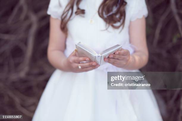 little girl taking communion - comunion fotografías e imágenes de stock