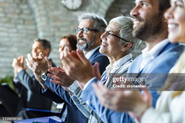 happy entrepreneurs applauding on education event in board room. - working seniors stock pictures, royalty-free photos & images