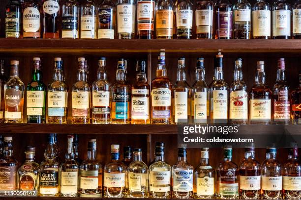 large selection of scottish malt whisky at the bar - whiskey stock pictures, royalty-free photos & images