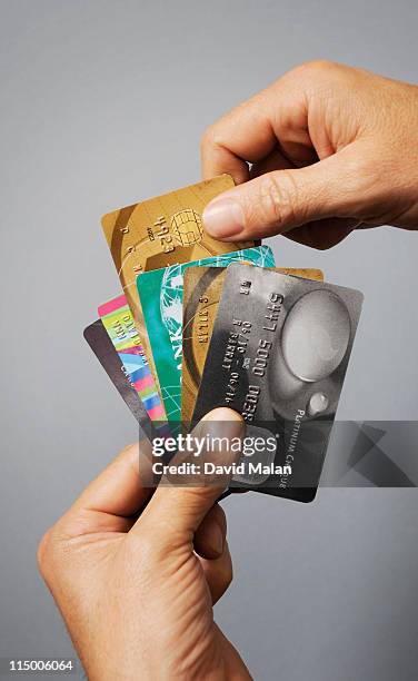 hands choosing a credit card, - credit cards fanned out stock pictures, royalty-free photos & images