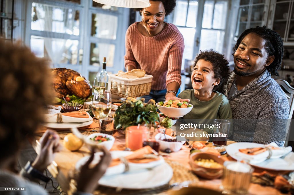 Happy African American family enjoying in Thanksgiving dinner at home.