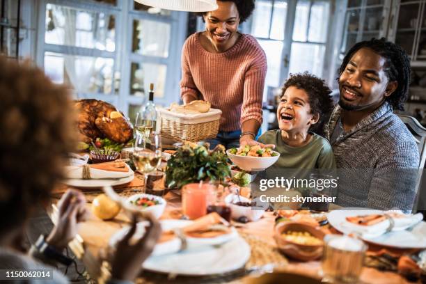 happy african american family enjoying in thanksgiving dinner at home. - friendsgiving stock pictures, royalty-free photos & images