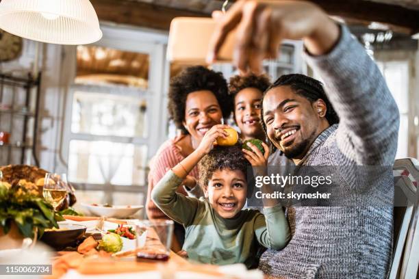 happy black family taking a selfie with cell phone in dining room. - photographing interior stock pictures, royalty-free photos & images