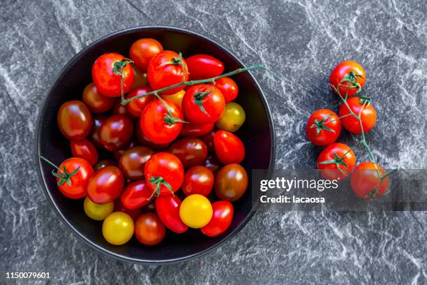 bowl with colorful cherry tomatoes - cherry tomatoes stock-fotos und bilder