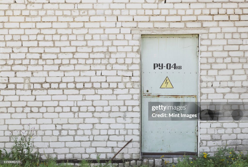 Factory Entrance With a Warning Sign