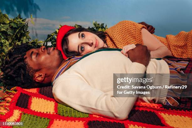 young couple laying on blanket outside - noapologiescollection stock-fotos und bilder