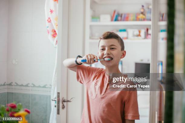 boy 11 brushing teeth in bathroom - brush teeth stock pictures, royalty-free photos & images