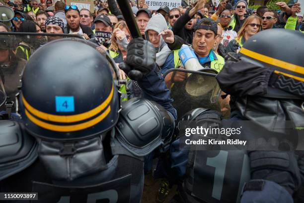 Gilets Jaunes and French Riot police clash as police try to push protestors back during demonstrations to mark the 6th month anniversary of the...