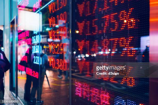 stock exchange market display screen board on the street showing stock market crash sell-off in red colour - crash stock pictures, royalty-free photos & images