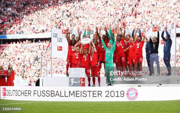 Manuel Neuer of Bayern Munich and team mates celebrate with the trophy following the Bundesliga match between FC Bayern Muenchen and Eintracht...