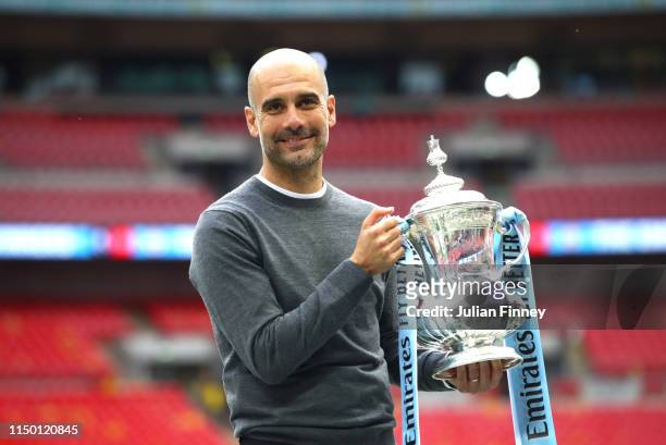 Josep Guardiola, Manager of Manchester City stops for a photograph with the trophy following victory in the FA Cup Final match between Manchester...