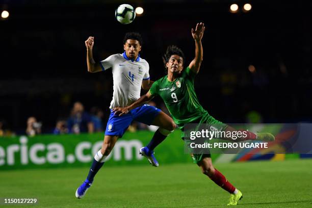 Brazil's Marquinhos and Bolivia's Marcelo Martins jump for the ball during their Copa America football tournament group match at the Cicero Pompeu de...