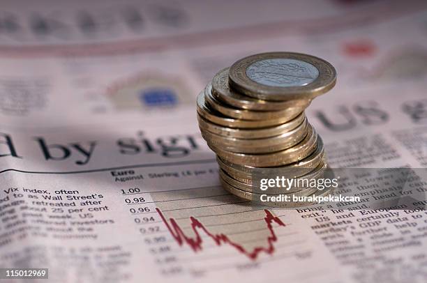 stack of coins on a financial newspaper, high angle view - western script stock pictures, royalty-free photos & images